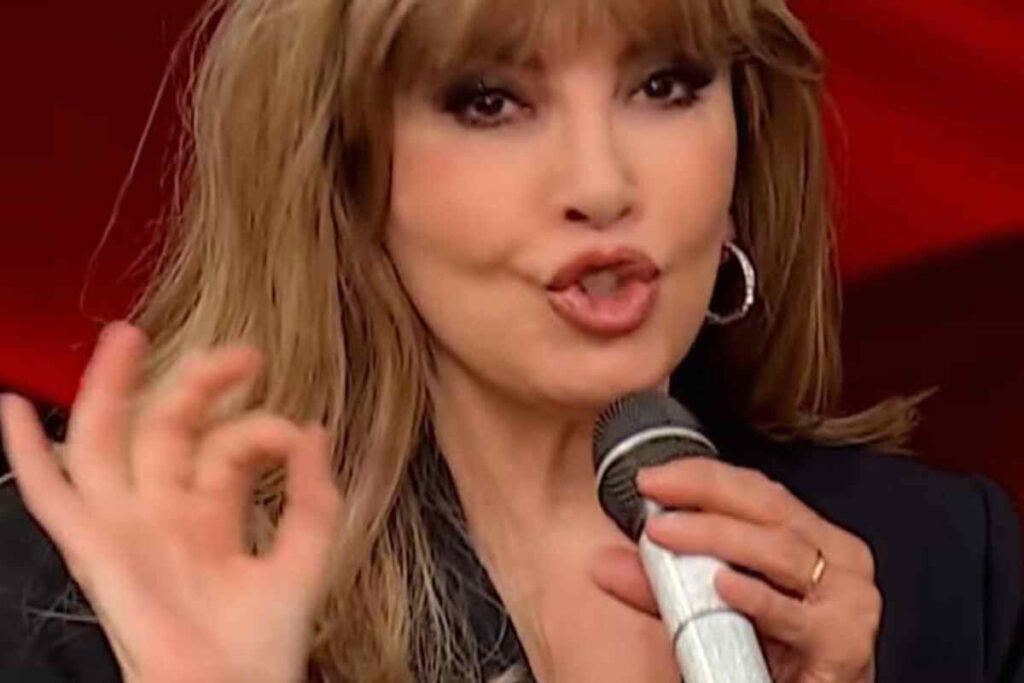 Milly Carlucci, ecco perché usa il microfono ‘gelato’: lo stesso gesto di un’altra regina, tutti i dettagli